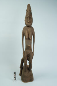 Image of a carved wooden statue of a female figure with a crocodile headdress