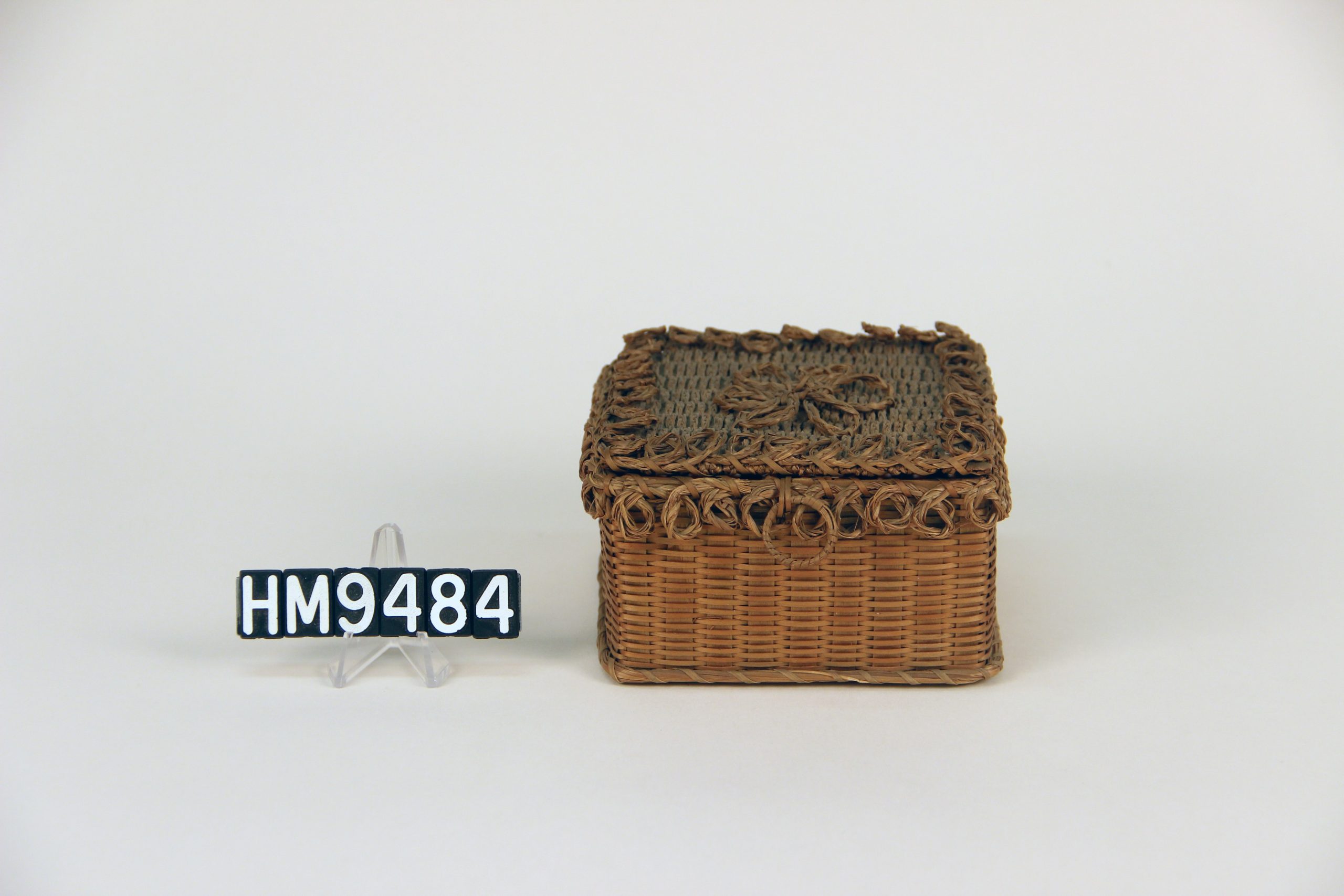 Image of small, square basket with decorative placement of sweetgrass braids.