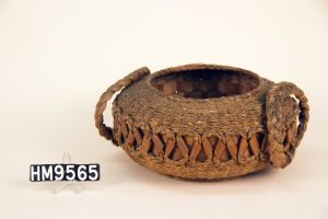 Round woven backet with flat laced sides, flat bottom and large braded side handles.