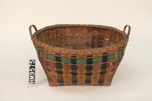 Image of a woven basket with a square bottom and a round top. Adorned with strips interwoven blue and green. 