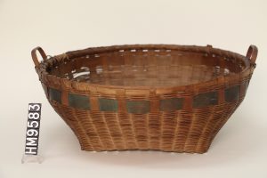 Image of a woven basket with a square bottom and a round top. Complete with round handles and a blue accent band. 