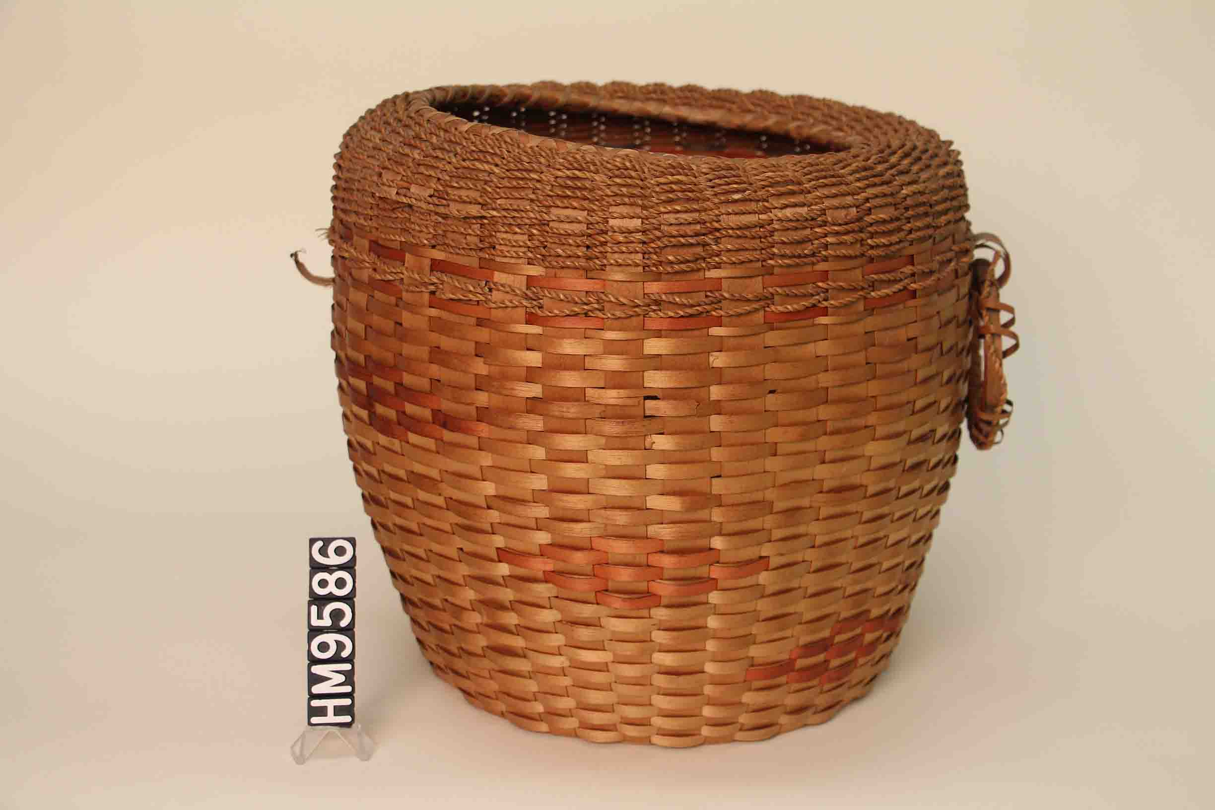 Image of tall basket that widens slightly from base. 