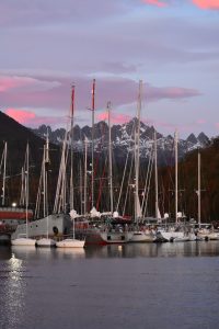 Sailboats docked in front pf a sunset