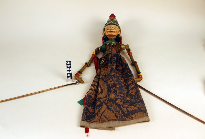 Image of puppet with rich textiles and sticks attached to hands.