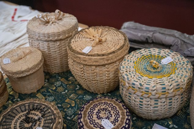 A variety of baskets sitting on a decorative holiday tablecloth.