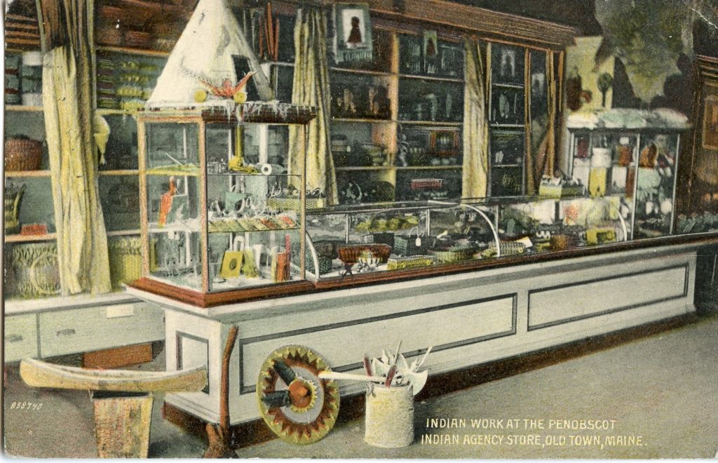 A colorized image of the inside of a store. There is a counter with glass cases and shelves behind the counter, all are filled with baskets, rootclubs, and other tourist items.