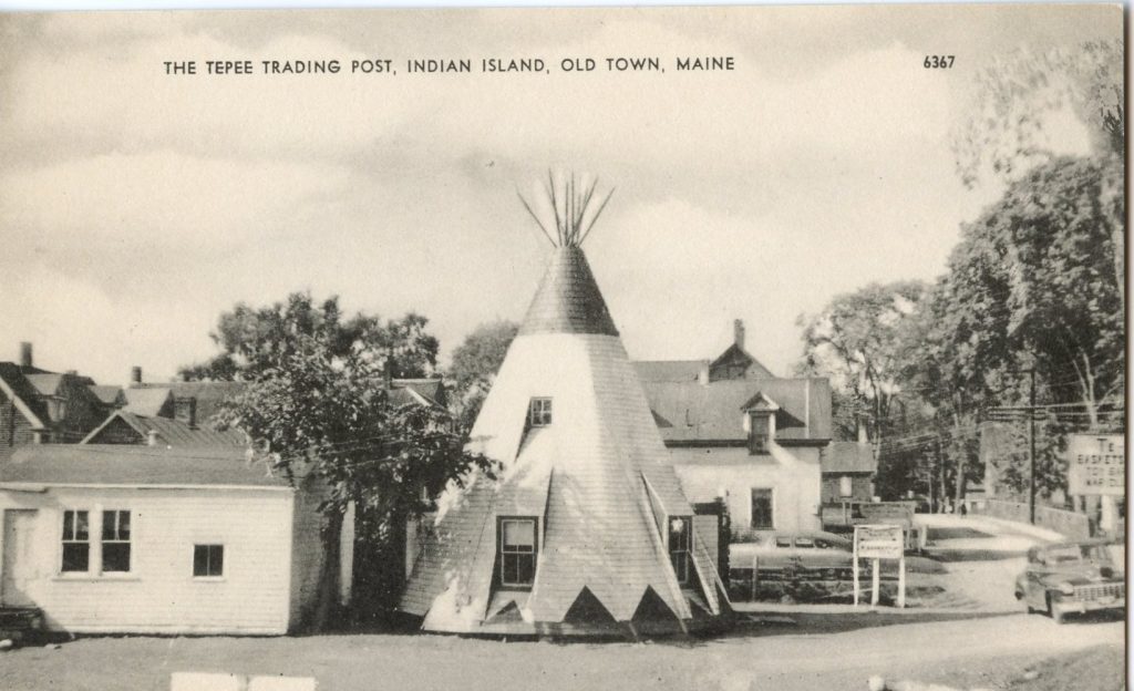 Grayscale image of a large, wooden, tepee-shaped building.