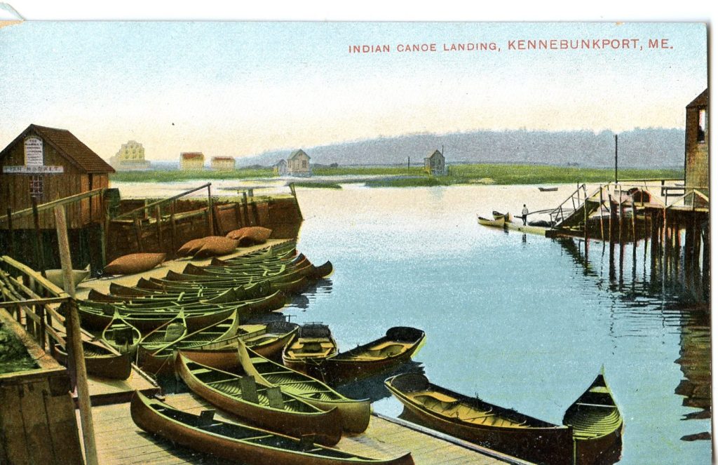 A colorized image of more than a dozen canoes along and on top of a dock. Buildings are seen next to the dock and on land just across the water.