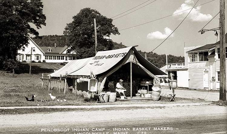 Black and white image of a canvas tent along a road. The tent reads "Indian Baskets"