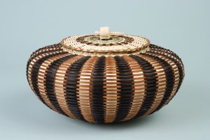 Urchin style basket with dark and light stripes.