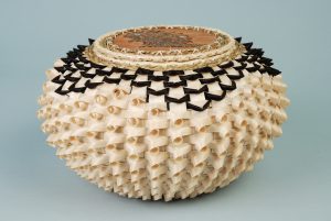 Urchin-shaped point basket with black details and a quillwork birchbark cover featuring a porcupine.