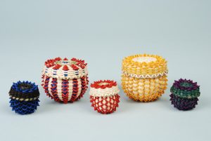 A collection of colorful point baskets, both miniature and small.