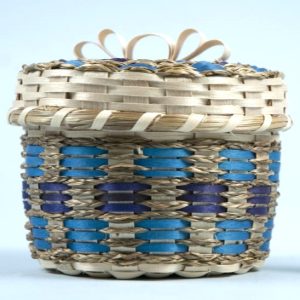 A basket with sweetgrass braids and brown ash in shades of blue.