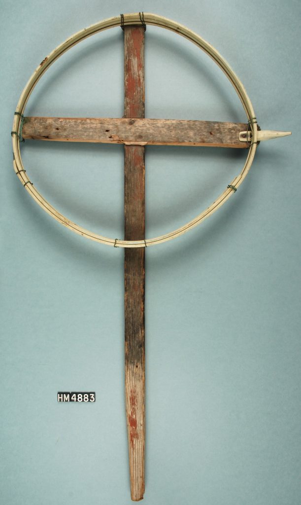 Image of an object made with two crossed pieces of wood and a circle of a lighter-colored material.