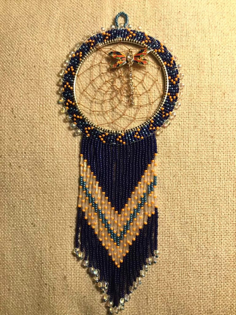 Image of small beaded dreamcatcher with beaded dragonfly element.