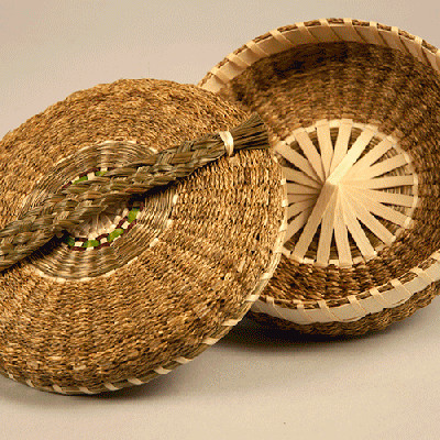 Image of open sewing basket woven with sweetgrass braids with a wide braided handle.