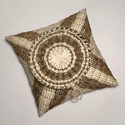 Image of square pillow-shaped basket with circular lid.