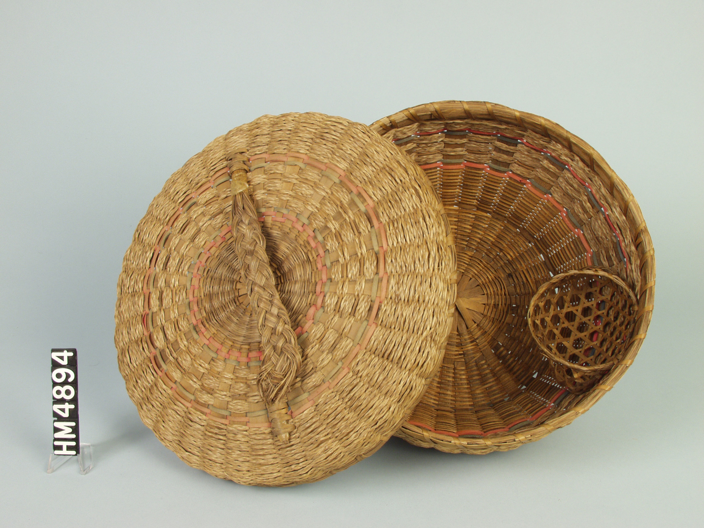 Image of basket, laying on side, with cover partially off showing inside of basket.