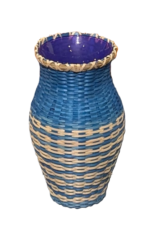 Image of basket woven around purple vase. Basket is tan and blue.