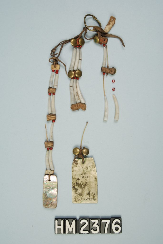 Image of a body ornament with bone, shell, and metal elements.
