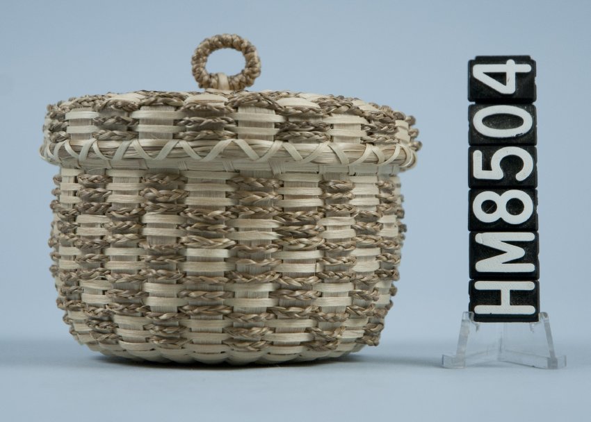 Image of small basket with checkerboard pattern made with brown ash and sweetgrass braids.