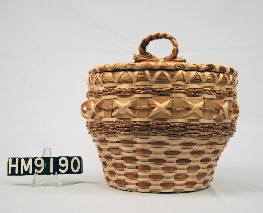 Image of basket with intricate details made with sweetgrass braids and brown ash curls.