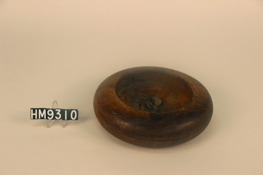 Image of a short, round block used for weaving urchin baskets.