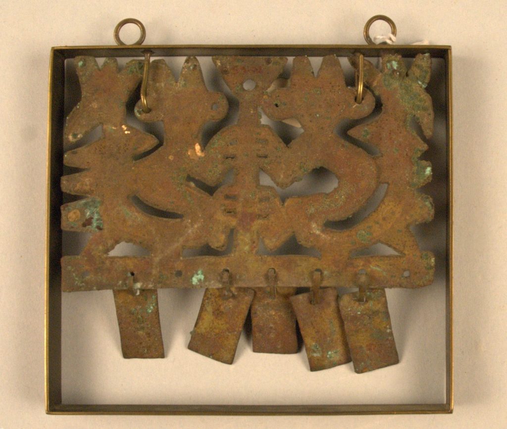 Image of ornament with two rings at top and various metal elements hanging inside a rectangular frame.