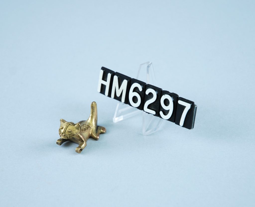 Image of small golden ornament in the shape of a cat.
