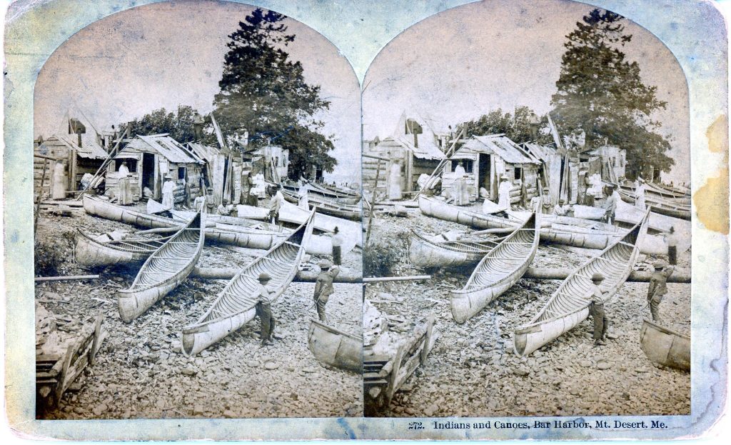 Two slightly off-set gray-scale images of an outdoor scene composed of small shacks made with scrap wood and an array of birchbark canoes with a scattering of figures.