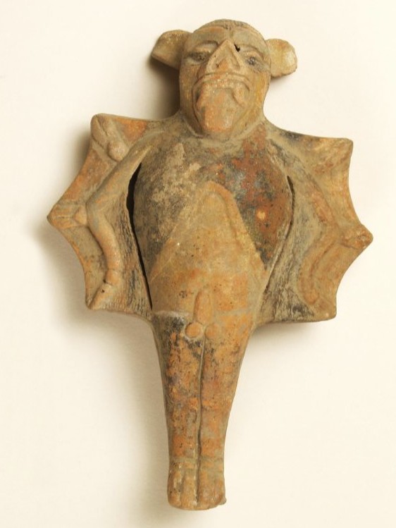 Ceramic object in the shape of a being with the body of a human male and the wings and head of a bat.