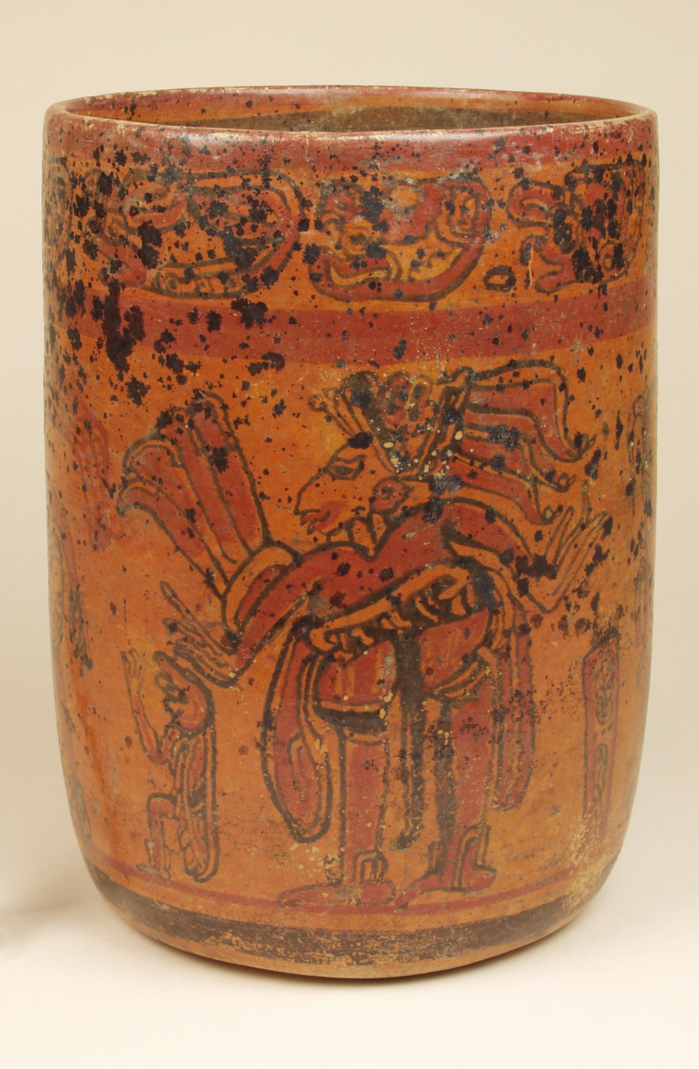 Ceramic vase, vertical sides that slightly contract toward base. Pained with red and black on orange. Black spots scattered across surface.