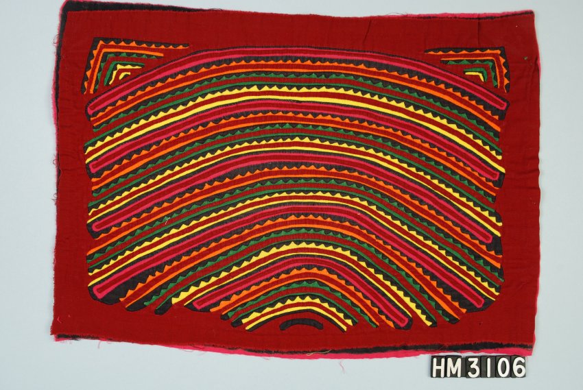 Rectangular fabric object with curved lines suggesting a rainbow