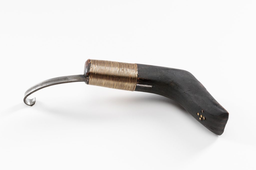 A hand tool with crooked wooden handle and hooked metal blade.