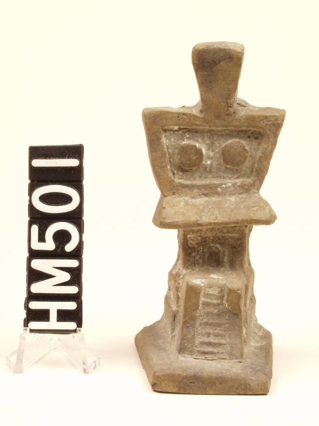 A small ceramic model of a temple, very simple, with largely rectangular elements.