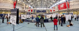 A panorama view of students presenting their work to symposium attendees