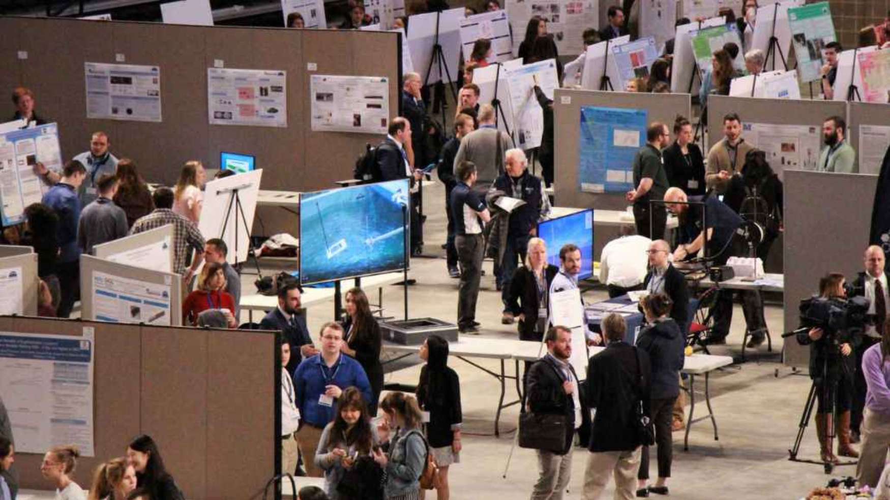 Image of people giving poster presentations at the UMaine Student Symposium.