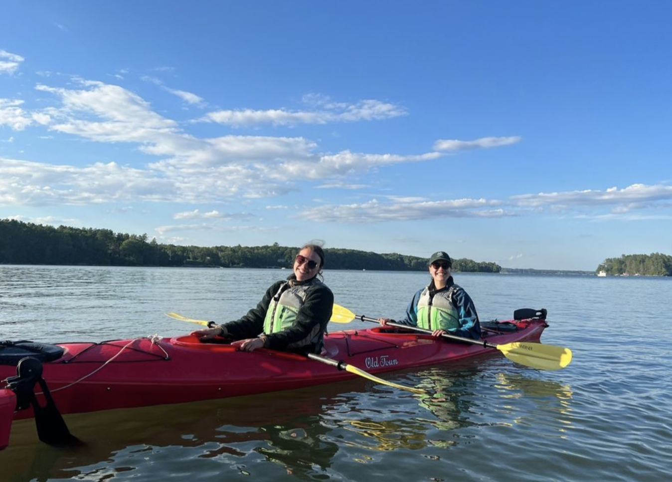 Two students in a tandem kayak on a lake
