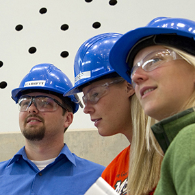 Three people wearing blue hard hats