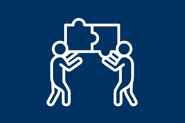 Two human figures fit puzzle pieces together