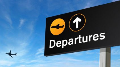 Sign with "Departures" on it. Airplane in background