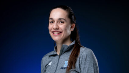 Picture of Blanca standing in from of a blue background, smiling