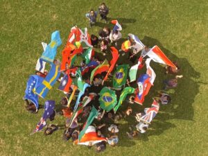 Picture from above of students with different flags from around the world.