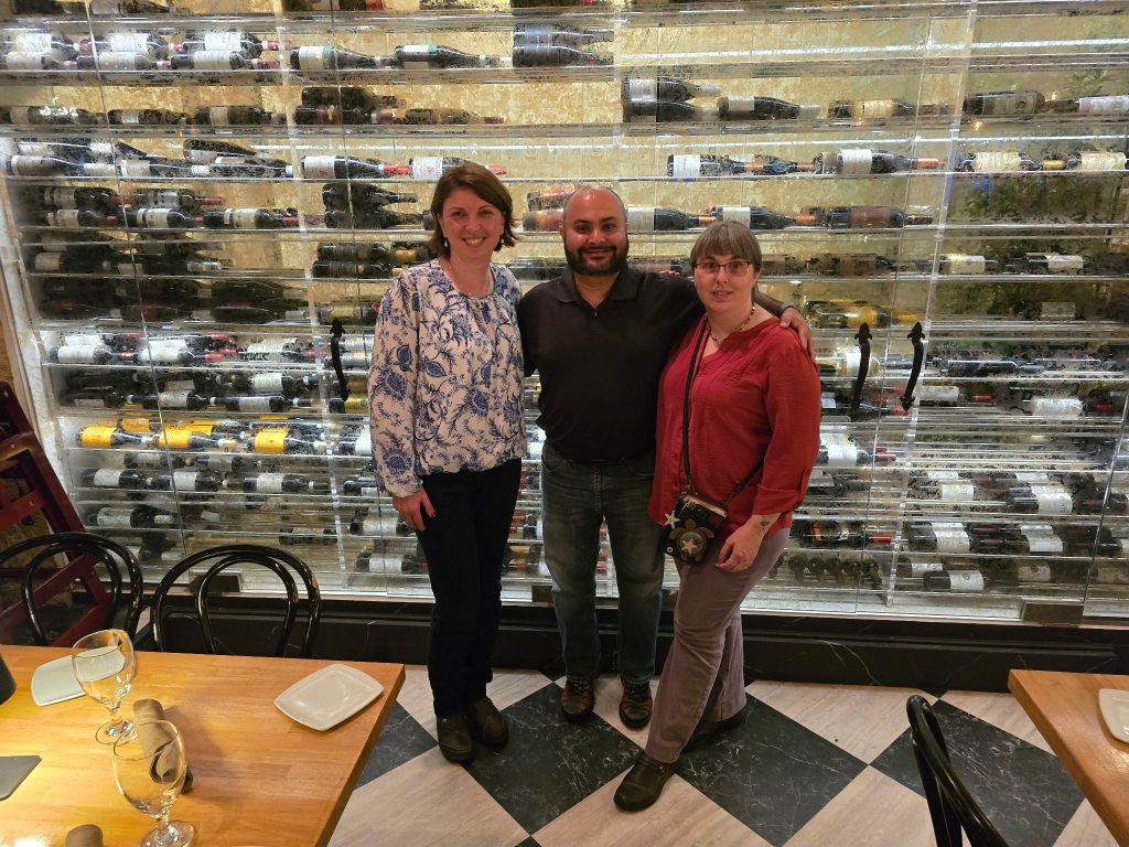 Orlina, Anuket, Carleena standing in front of a counter