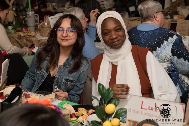 Two IEI students sitting at a table and posing for picture