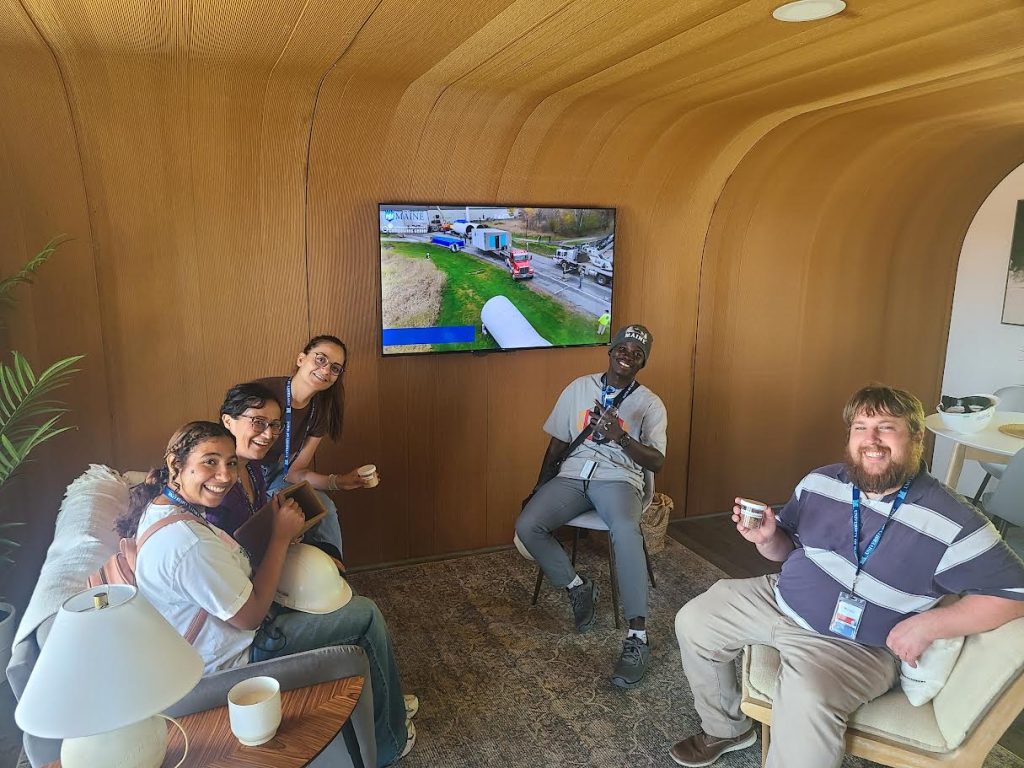 IEI group sits in living room space facing camera