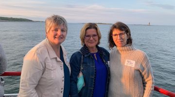 Mireille, guest, and Sarah in group photo on a boat
