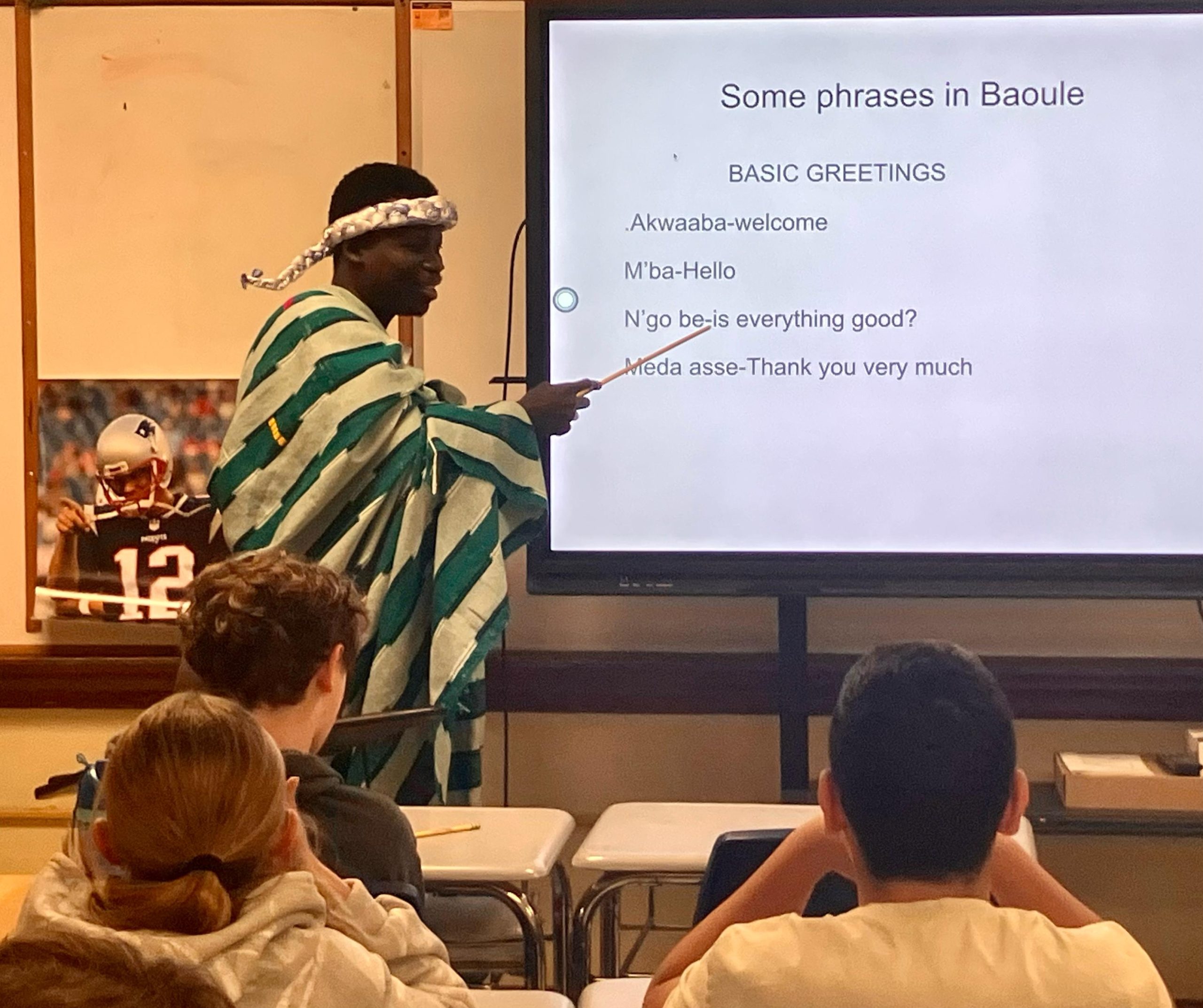 Frank wearing cultural garb while presenting to young students