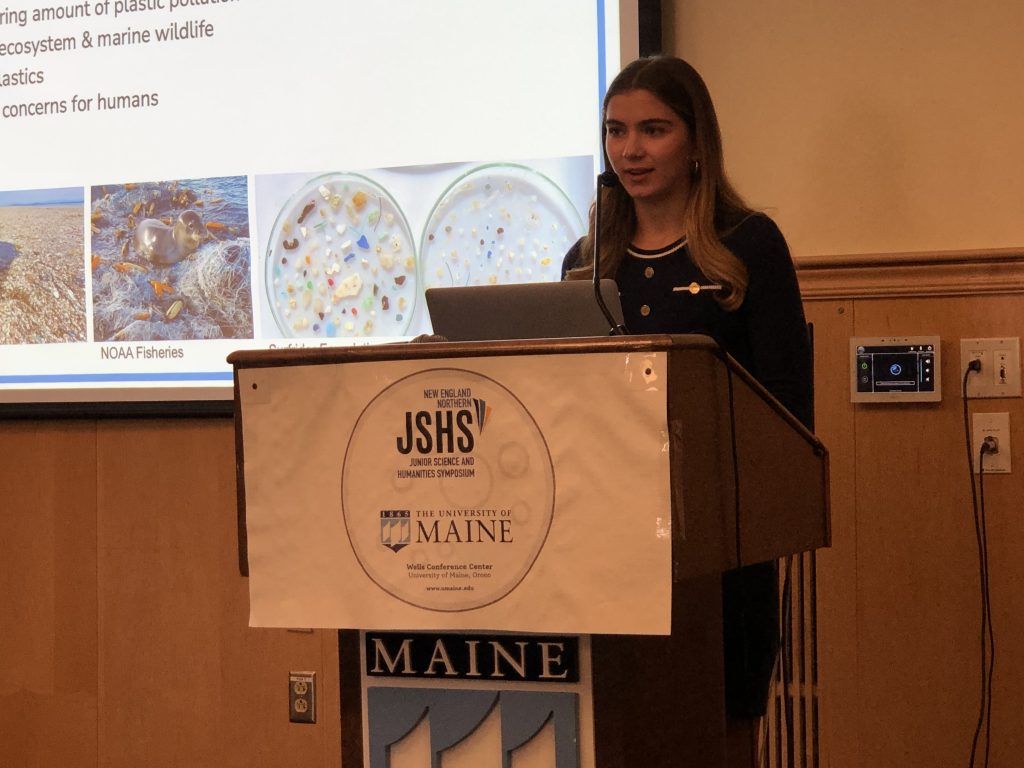 A photo of a student presenting at the podium