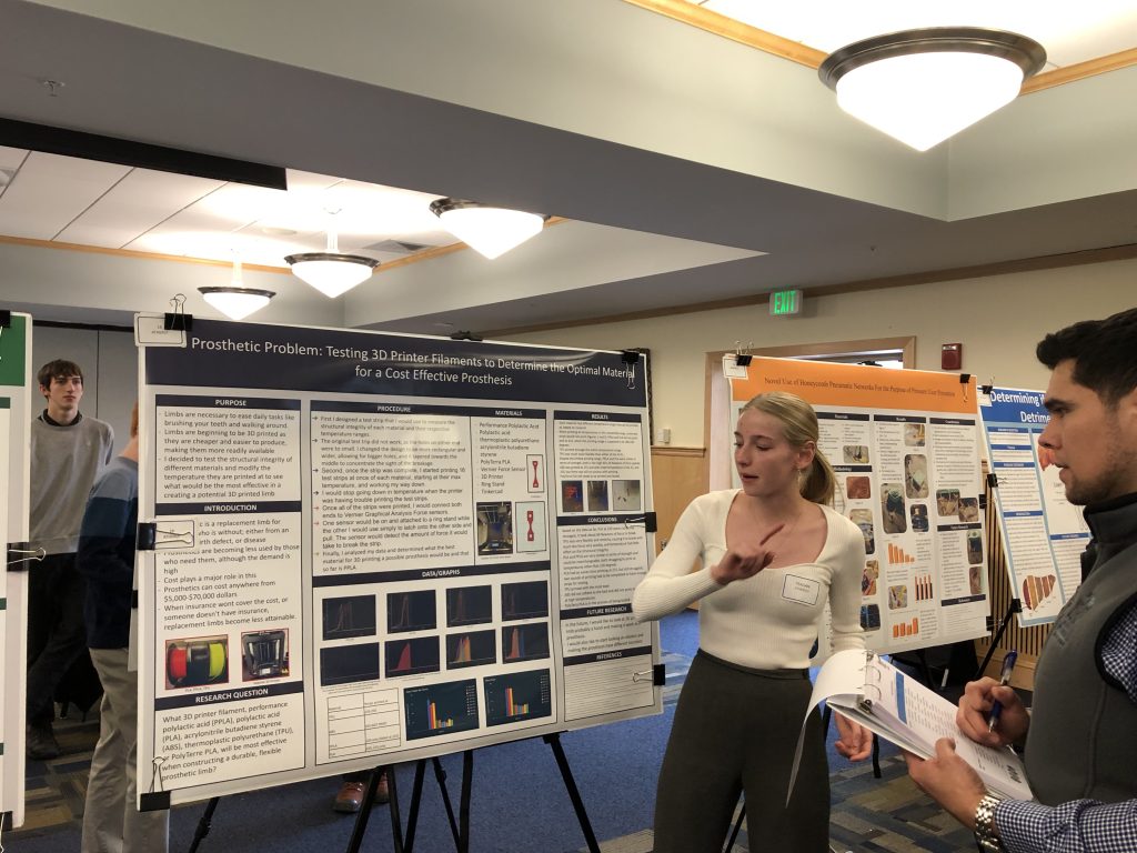 A photo of a student with their poster